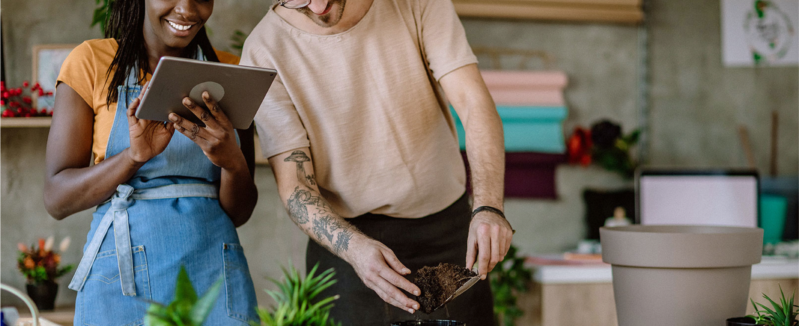 Shop owners look at a tablet.