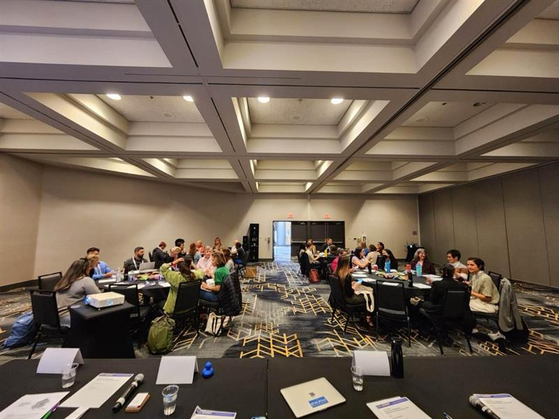 A room full of people sitting at tables at the Bixal workshop at the Code for America Summit,