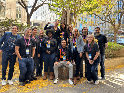 A large group of Bixal team members pose together for a photo outside the Drupal GovCon conference.