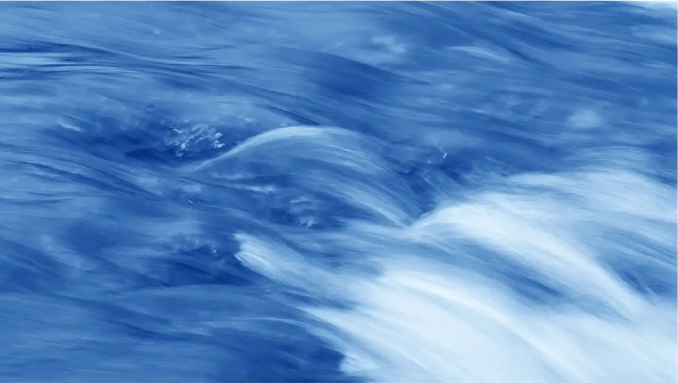 An image of blurry, soft flowing, blue water.