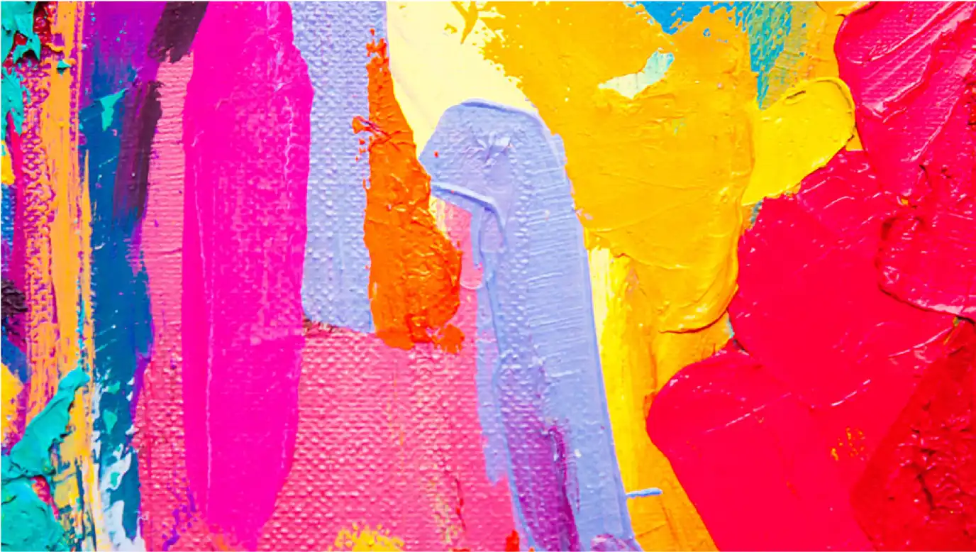 A close-up of a random assortment of smeared, bright acrylic paints.